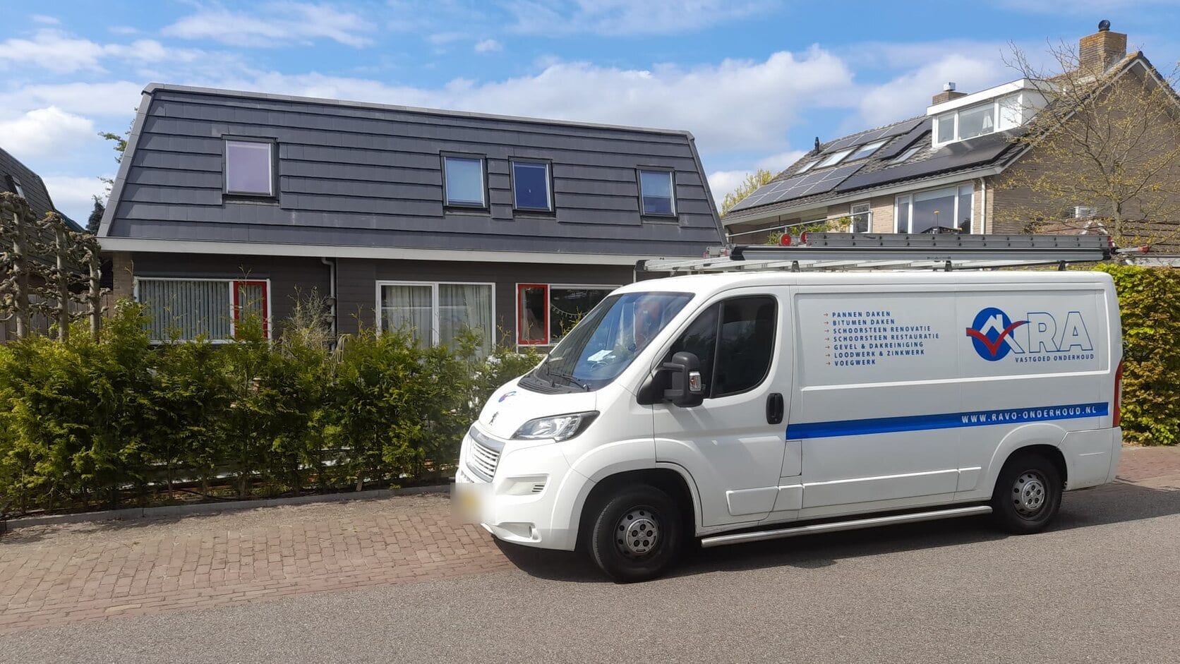 Een twee-onder-een-kap met een nieuw dak van grijze pannen, de bus ervoor