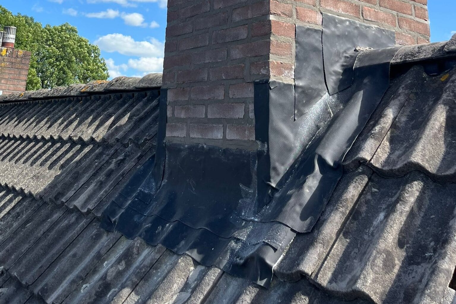 Na de renovatie: opnieuw gevoegde schoorsteen met nieuw lood en strakke dakpannen