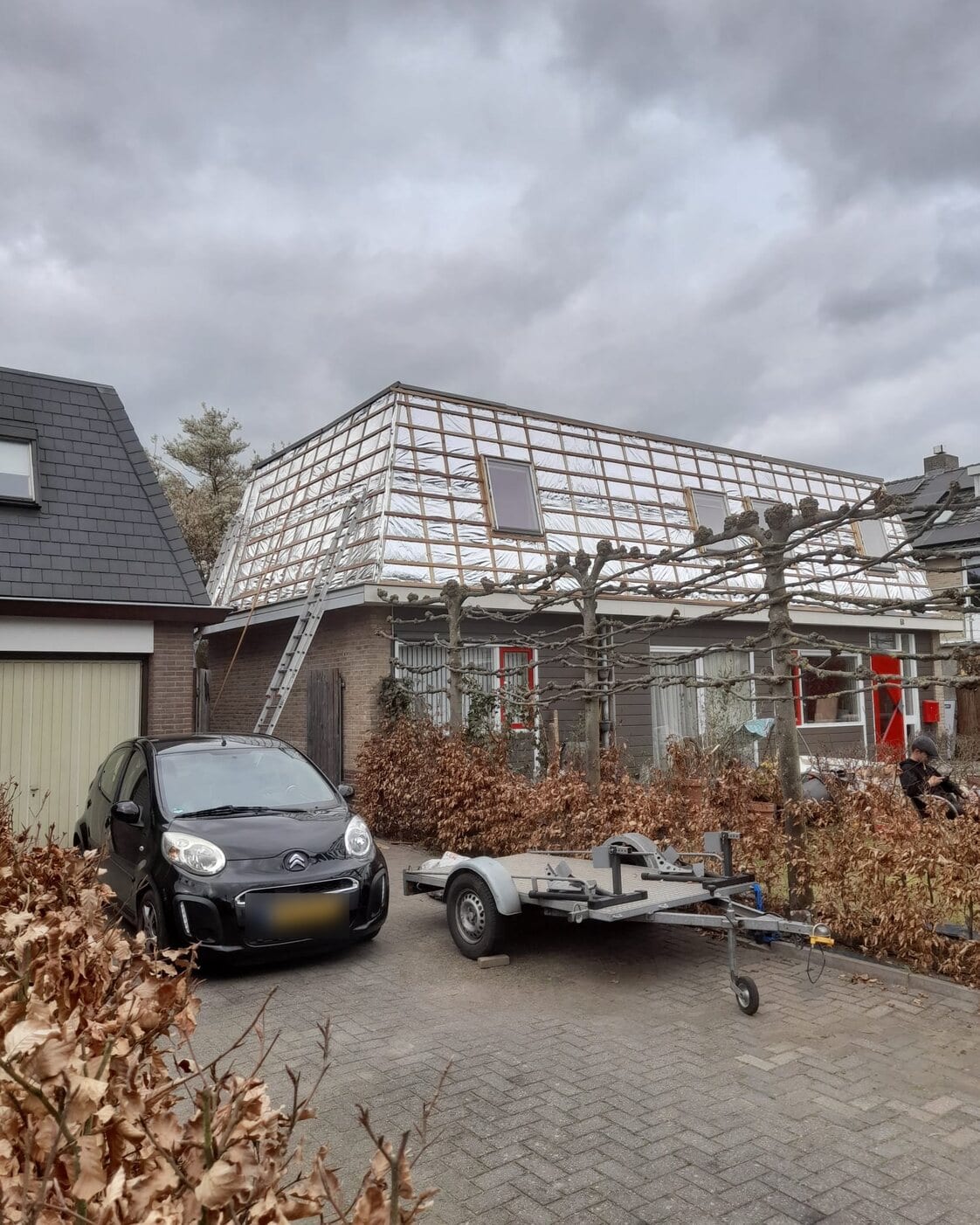 Woonhuis tijdens dakrenovatie met isolatiefolie op het dak en dakkapellen in aanbouw