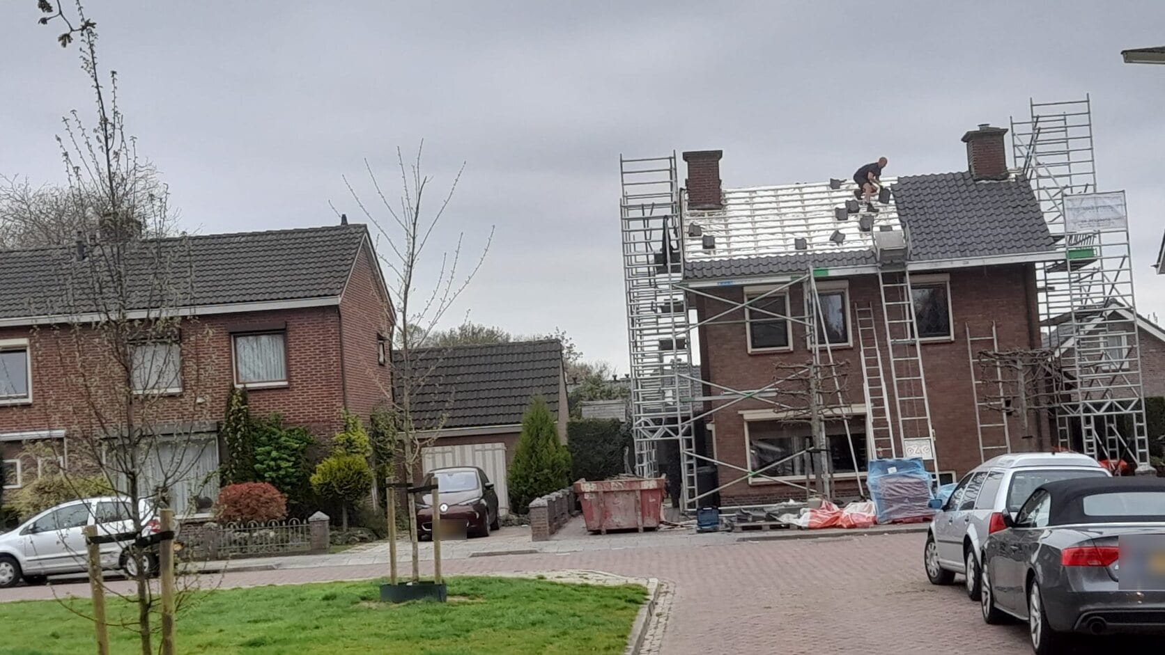 Woonstraat met een woning in de steigers voor dakwerkzaamheden